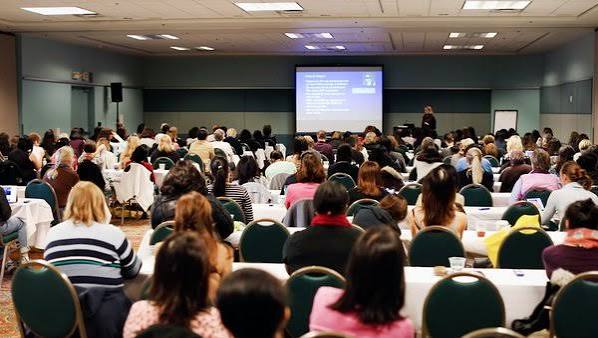 Clinicians seated in a conference hall audience