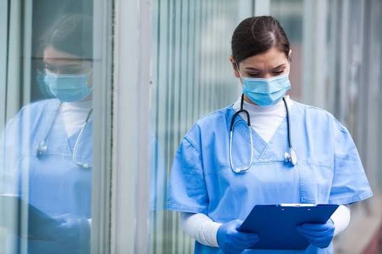 Nurse with a clipboard in a hospital corridor