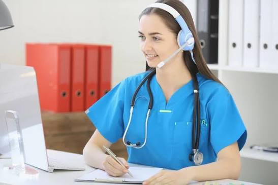 Nurse wearing a headset while writing at a desk