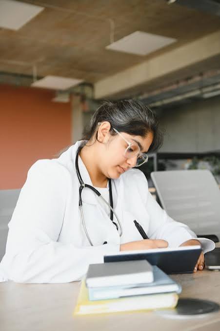 Student in a white coat studying with a stethoscope